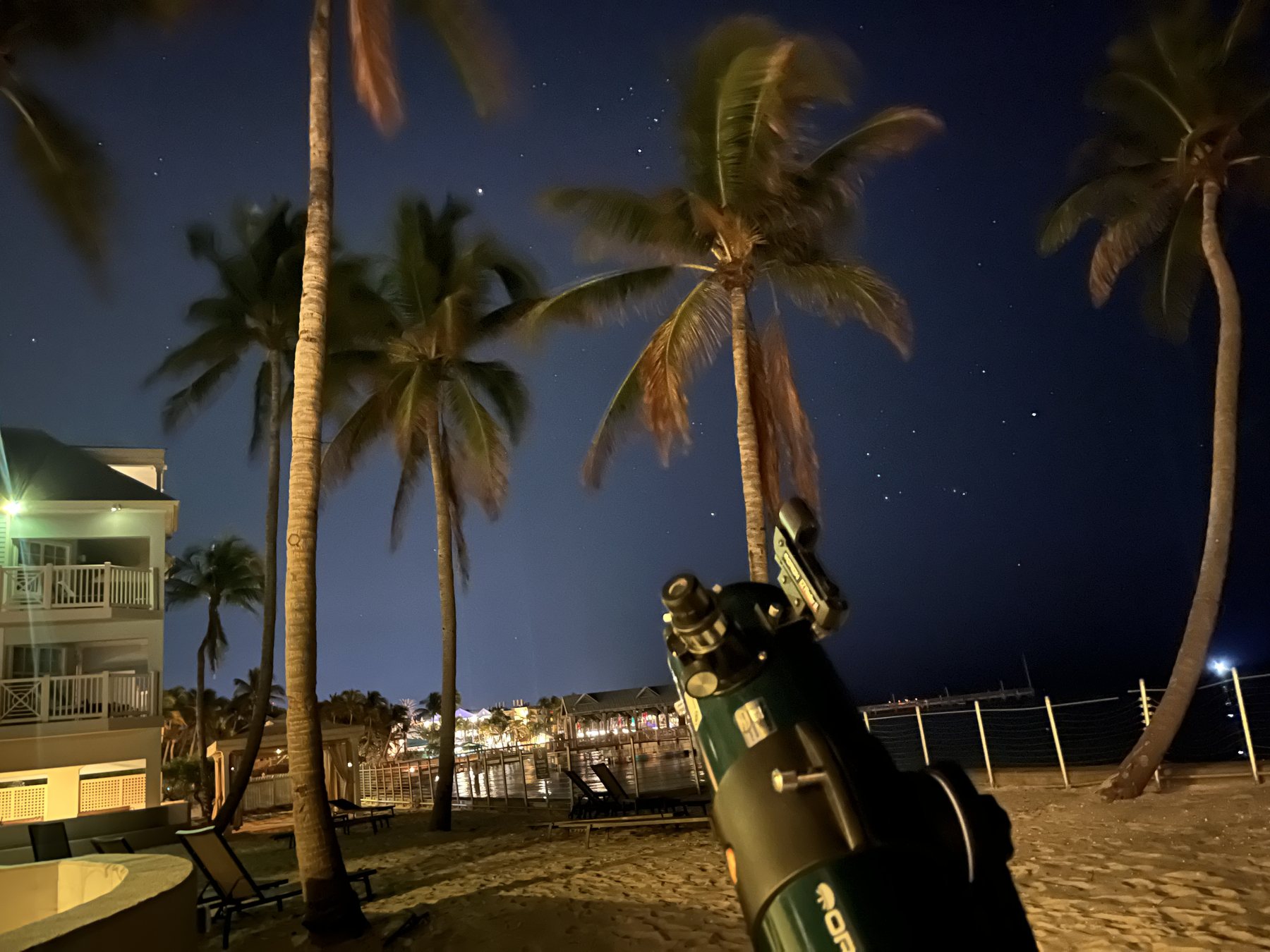 A telescope under a starry sky during an evening beach astronomy experience