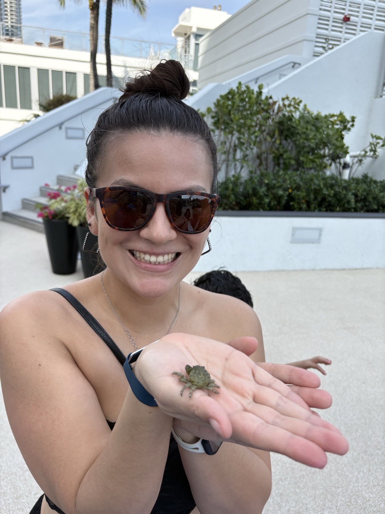 Guest holding a small emerald crab during a resort marine encounter