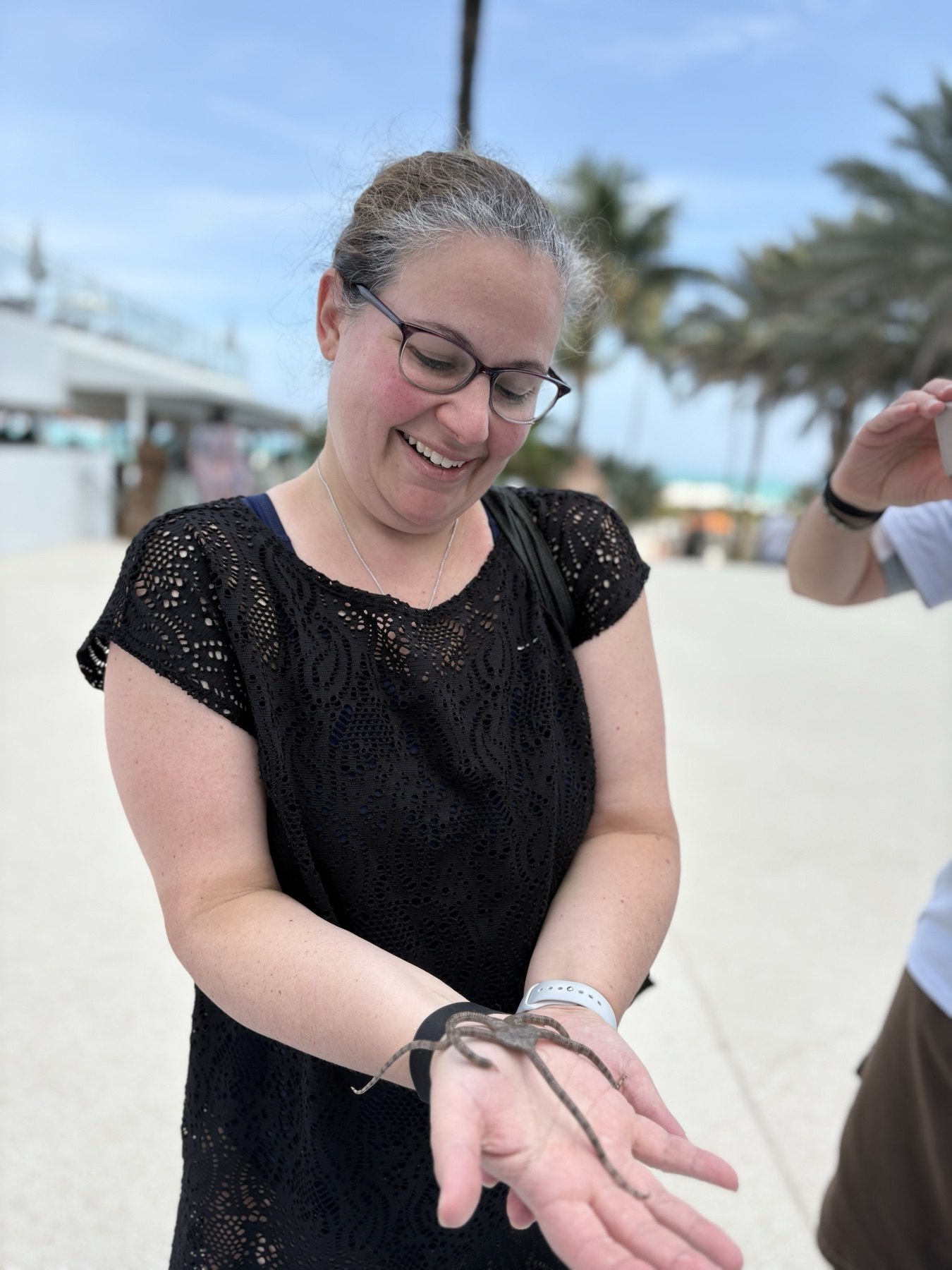 Guest holding a serpent star during a hands-on coastal wildlife activity