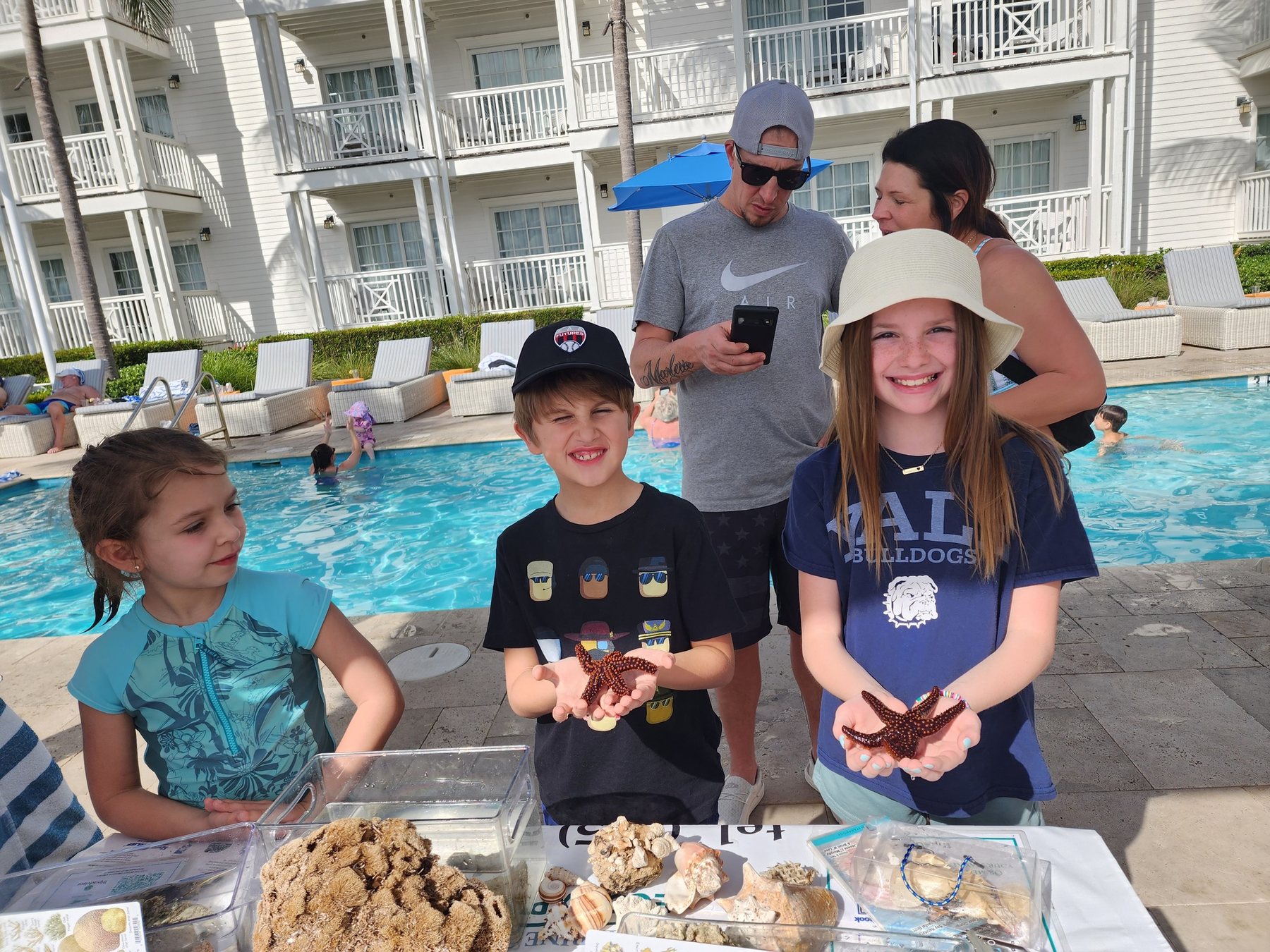 Guests holding sea stars during a hands-on marine science program