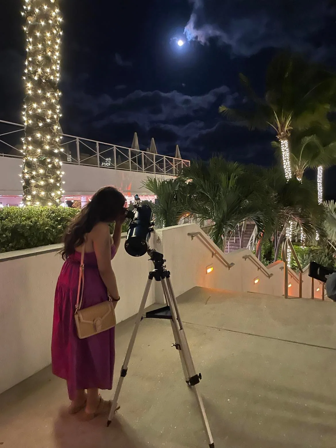 An adult guest looking through a telescope during an evening resort astronomy experience