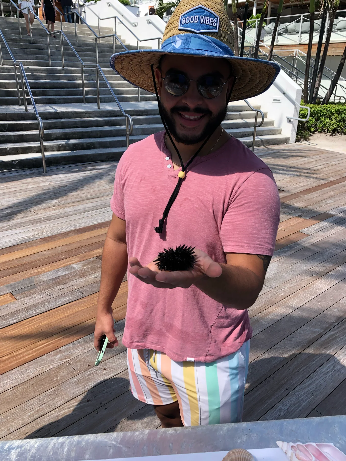 An adult resort guest holding a sea urchin during a hands-on marine activity
