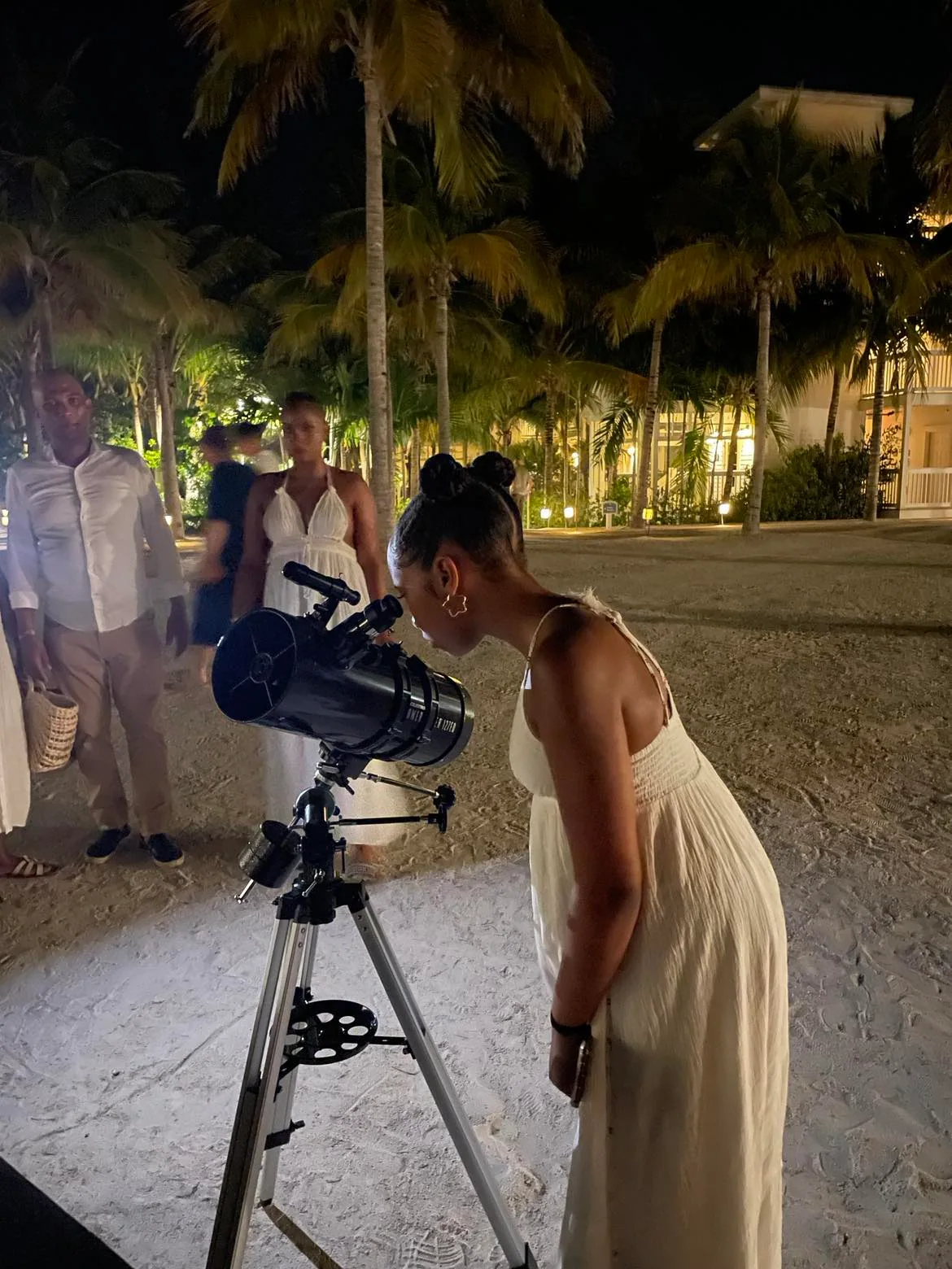 A resort guest observing the night sky through a telescope